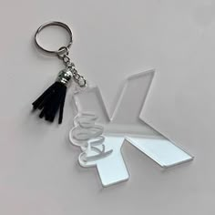 a keychain with the letter v and tassels hanging from it's side