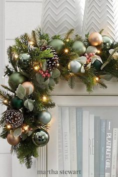 a mantle decorated with christmas ornaments and pine cones