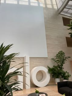 a large white sign sitting in the middle of a living room next to a plant