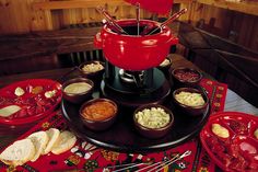 a table topped with red dishes filled with food