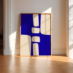 a blue and white abstract painting in an empty room with wood flooring next to it