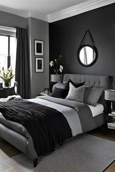 a bedroom with black walls and grey bedding in the corner, along with a round mirror on the wall