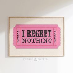 a pink ticket with the words i regret nothing printed on it hanging from a wall