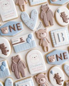 cookies decorated with teddy bears and other baby related items are arranged on a white surface