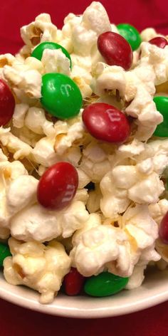 a white bowl filled with candy covered popcorn