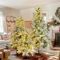 two artificial christmas trees in a living room decorated for the holidays with lights on them