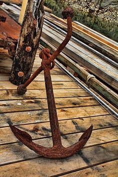 an anchor sitting on top of a wooden dock