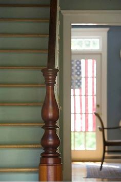 an american flag is hanging on the wall next to a wooden post in a room