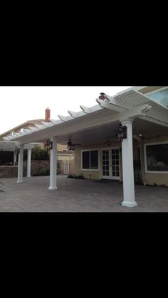 an outdoor covered patio with white columns