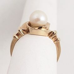 "A whirl of a pearl ring! This vintage 14K gold ring has a design that makes it distinctive without losing its classic look. The cultured pearl has nice, consistent color and is centered in a hurricane style setting. Stepped shoulders add another unique twist to this ring which is in wonderful condition. Vintage: 1960s - 1980s Size: 6 1/2 Materials: 14K Yellow Gold, Cultured Pearl Marked: 14K Pearl: 6.7mm diameter Width North to South: 7/16\" Width East to West: 3/4\" Stands Off Finger: 5/16\" S Timeless 14k Gold Pearl Ring Hallmarked, Classic 14k Gold Hallmarked Pearl Ring, Vintage 14k Gold Pearl Ring, 14k Yellow Gold Pearl Ring With Polished Finish, Vintage Gold Hallmarked Pearl Ring, Resize Ring, Kids Rings, Carnelian Ring, 14k Gold Ring