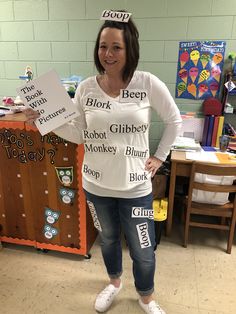 a woman standing in front of a table with signs on it that spell out words