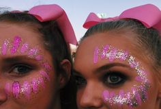 two girls with pink and silver glitter make - up on their faces, one girl has her eyes closed