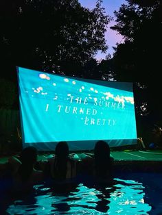 people are sitting in the water watching a screen that says, i turned and pretty