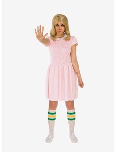 a woman in a pink dress and striped socks is holding her hand up to the side