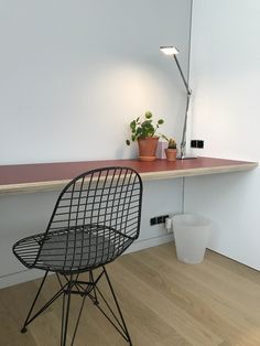 a black chair sitting next to a table with a potted plant on it