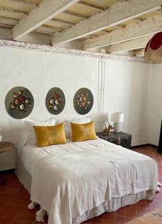 a white bed sitting in a bedroom on top of a red tiled floor