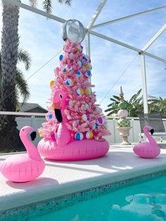 an inflatable pink christmas tree next to a pool with flamingos on it