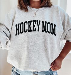 a woman wearing a sweatshirt that says baseball mom