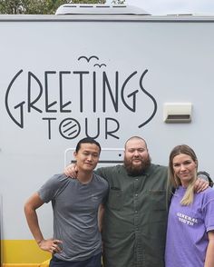 three people standing next to each other in front of a white truck with the words greetings tour written on it