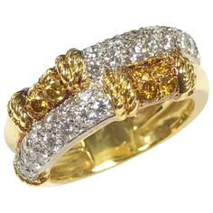 a yellow and white diamond ring with two rows of diamonds on the band, set in 18k gold