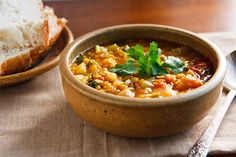 a bowl of soup with bread on the side