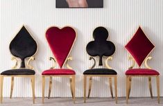 four chairs with hearts and spades on them in front of a wall mounted painting