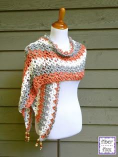 a crocheted shawl is displayed on a mannequin