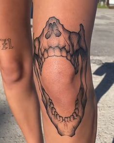 a woman's leg with a tattoo on it that is shaped like a skull