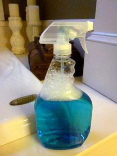 a blue bottle filled with liquid sitting on top of a sink