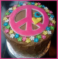 a cake decorated with flowers and peace signs