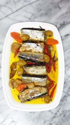 an image of fish with olives and peppers on a plate