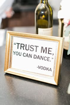 a sign that says trust me, you can dance vodka and two wine bottles behind it