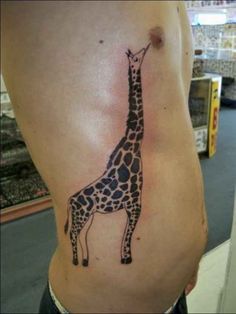 a giraffe tattoo on the side of a man's stomach is shown