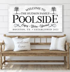 a wooden bench sitting in front of a white wall with a sign that says, welcome to the hudson family poolside