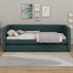 a green couch sitting on top of a hard wood floor next to a white rug