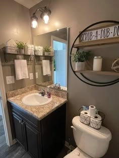 a bathroom with a toilet, sink and mirror in it's centerpieces