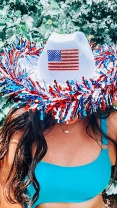 a woman wearing a straw hat with an american flag on it