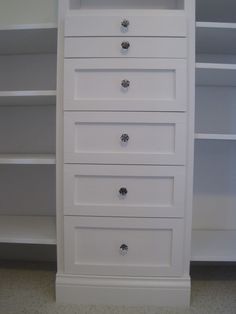 a white dresser with five drawers in a room