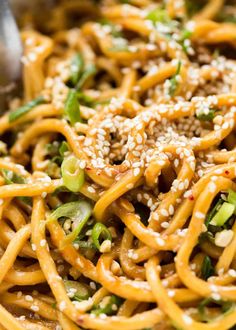 a close up view of some noodles with sesame seeds and other things in the background