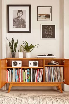 an entertainment center with books, speakers and pictures on the wall