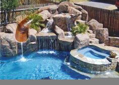 an outdoor pool with waterfall and rock walls