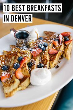 french toast with berries, blueberries and whipped cream on top sitting on a white plate