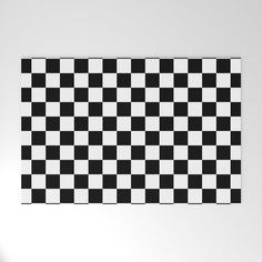 a black and white checkerboard wall hanging on the side of a wall in an empty room