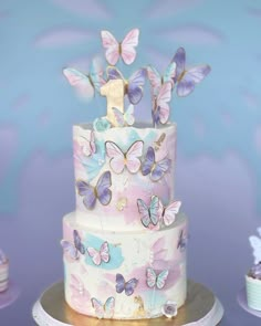 there is a three layer cake with butterflies on it