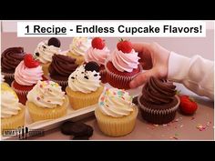 cupcakes with chocolate frosting and strawberries are on a white plate next to a hand