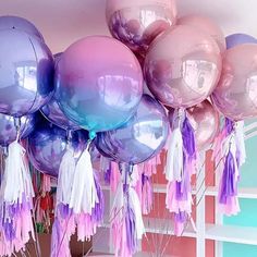 purple and pink balloons with tassels hanging from the ceiling