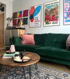 a living room filled with green couches and pictures on the wall above their coffee table