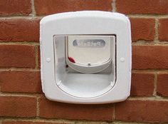 a wall mounted toilet paper dispenser on a brick wall