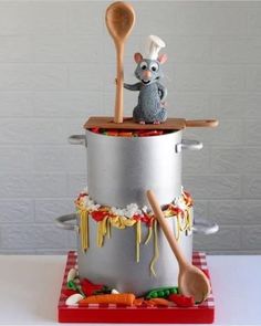 a cake made to look like a pot and pan with a mouse in it on top