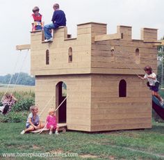 children playing in a cardboard castle made to look like it has been built into the ground